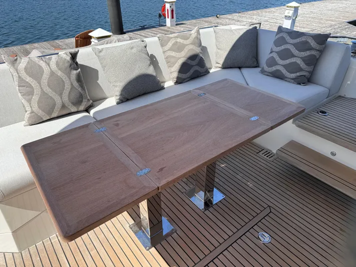  Yacht Photos Pics Luxurious seating area on 2023 Prestige 520 F-Line yacht with wooden table and cushions.