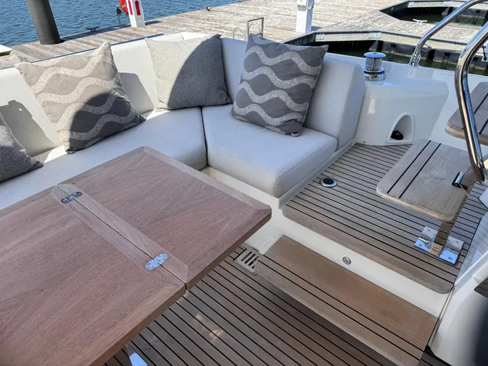  Yacht Photos Pics Luxurious seating area on 2023 Prestige 520 F-Line yacht with wooden table and cushions.