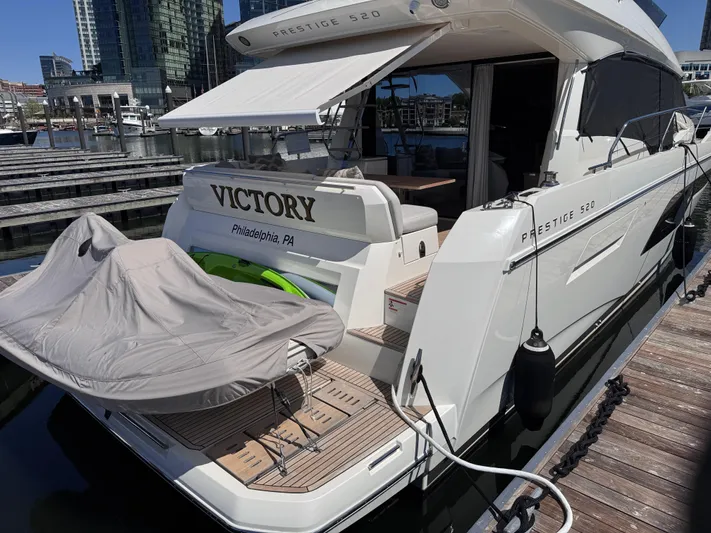  Yacht Photos Pics 2023 Prestige 520 F-Line yacht docked, featuring "Victory" name and covered equipment.