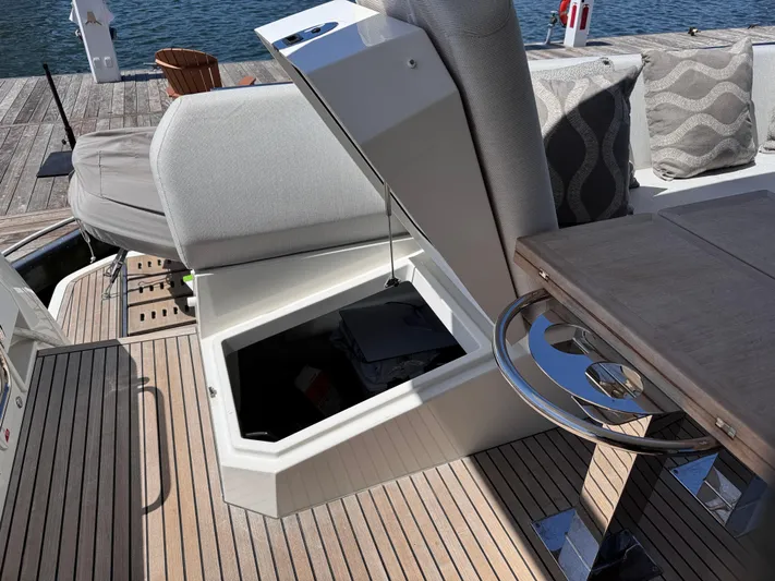  Yacht Photos Pics 2023 Prestige 520 F-Line yacht deck with open storage compartment and seating area.