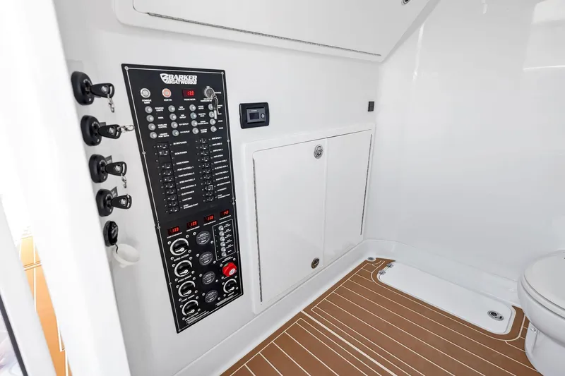  Yacht Photos Pics Control panel inside 2022 Barker Boatworks 40 HPC, featuring modern switches and wood-patterned flooring.