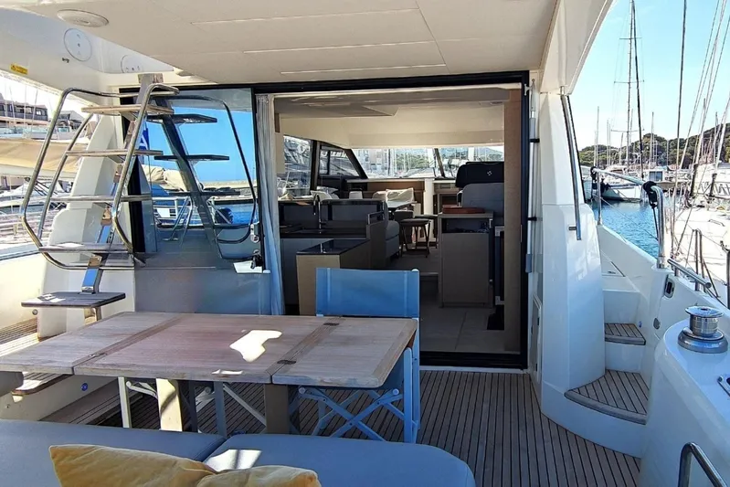  Yacht Photos Pics 2023 Jeanneau Prestige 520 Fly yacht interior with outdoor seating and marina view.