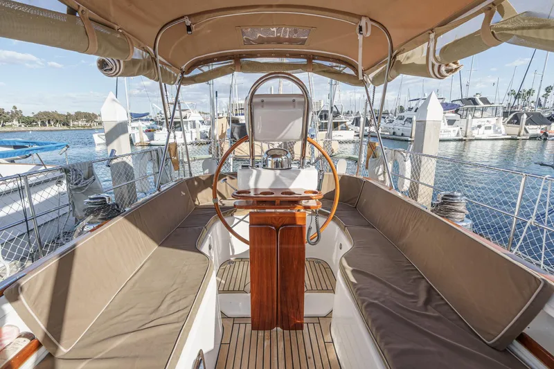 Feather Yacht Photos Pics Spacious cockpit of 2012 Hylas 46 yacht with wooden accents and marina view.