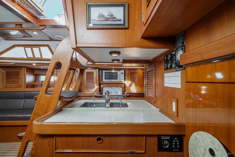 Feather Yacht Photos Pics Luxurious 2012 Hylas 46 yacht interior with wooden cabinetry and modern kitchen amenities.