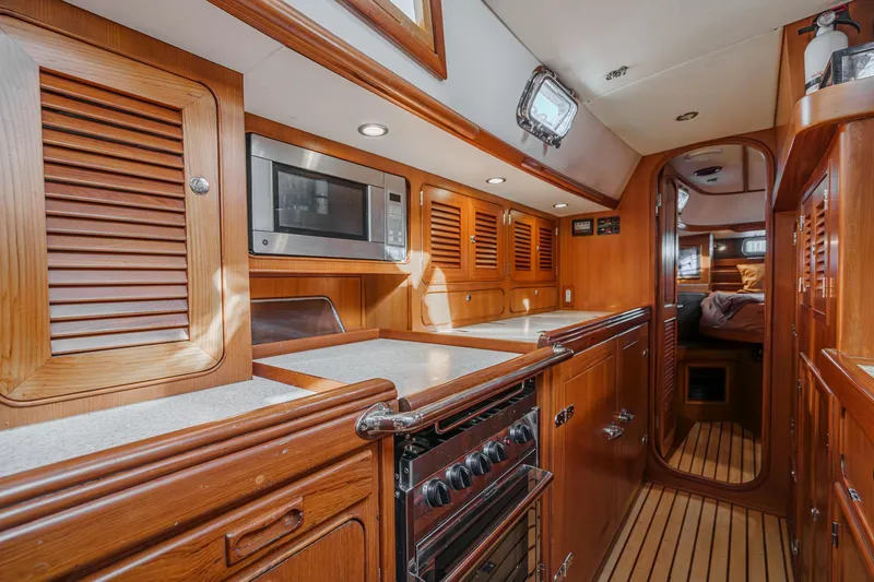 Feather Yacht Photos Pics Luxurious 2012 Hylas 46 yacht interior with wooden cabinetry and modern kitchen amenities.