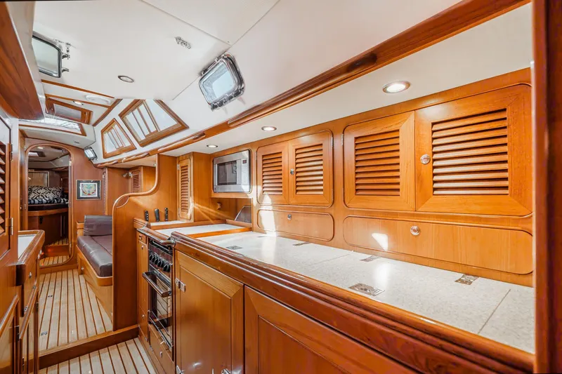 Feather Yacht Photos Pics Luxurious interior of 2012 Hylas 46 yacht with wooden cabinetry and modern amenities.