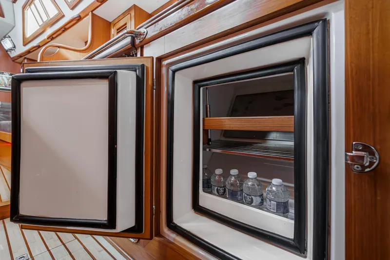 Feather Yacht Photos Pics Open fridge on 2012 Hylas 46 yacht interior with water bottles inside.