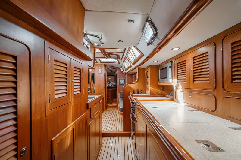 Feather Yacht Photos Pics Luxurious interior of 2012 Hylas 46 yacht with wooden cabinetry and modern amenities.