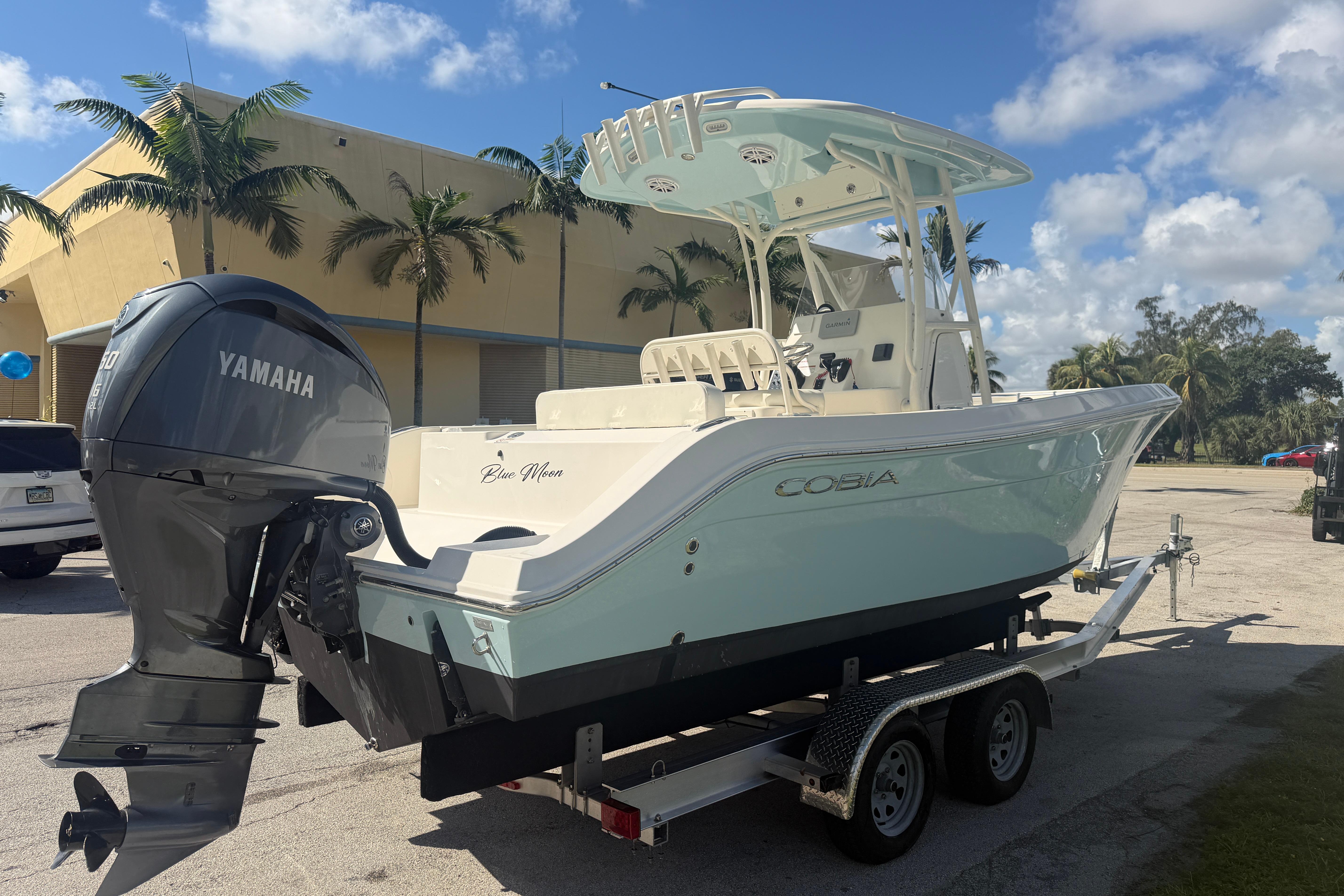 2021 Cobia 237 Center Console boat on trailer with Yamaha engine, parked outdoors.