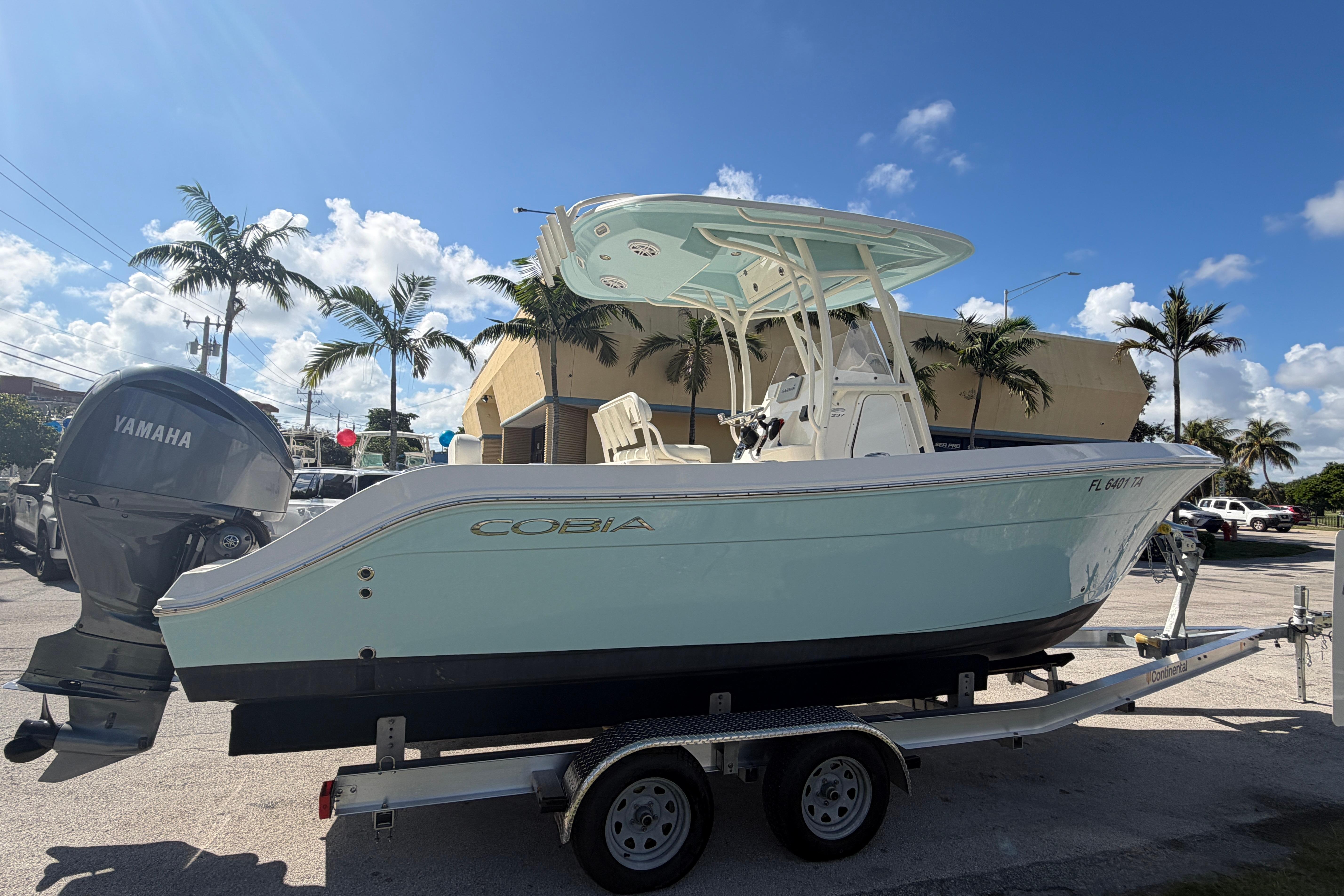 2021 Cobia 237 Center Console boat on trailer, with Yamaha engine, parked outdoors.