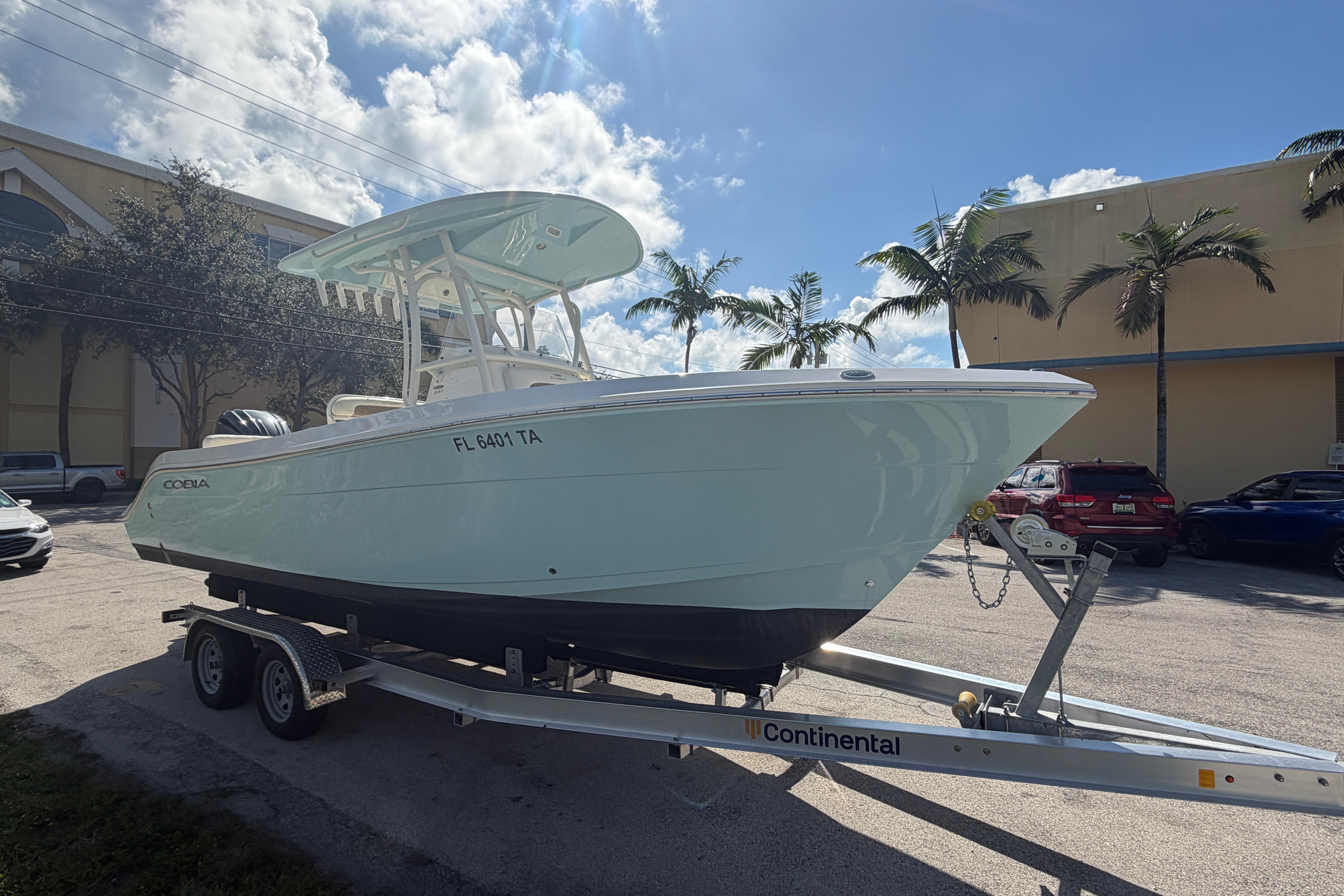 2021 Cobia 237 Center Console boat on trailer, parked outdoors under a sunny sky.