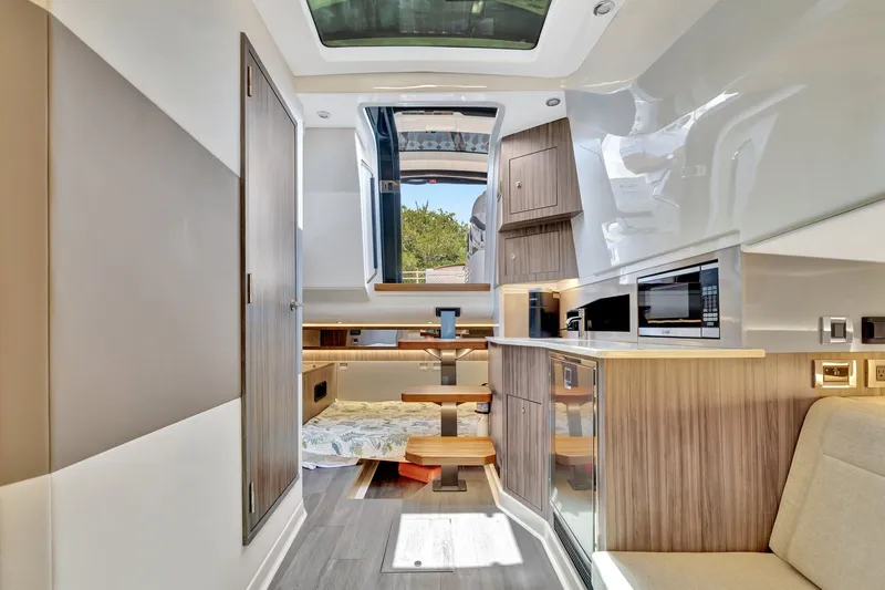  Yacht Photos Pics Luxurious interior of 2024 Sea Ray Sundancer 370 Outboard, featuring modern kitchen and seating area.