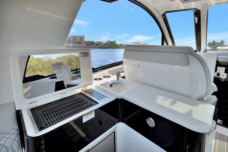  Yacht Photos Pics 2024 Sea Ray Sundancer 370 Outboard interior with sleek kitchenette and scenic water view.