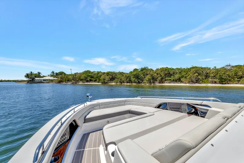  Yacht Photos Pics 2024 Sea Ray Sundancer 370 Outboard cruising near a scenic shoreline under a clear blue sky.