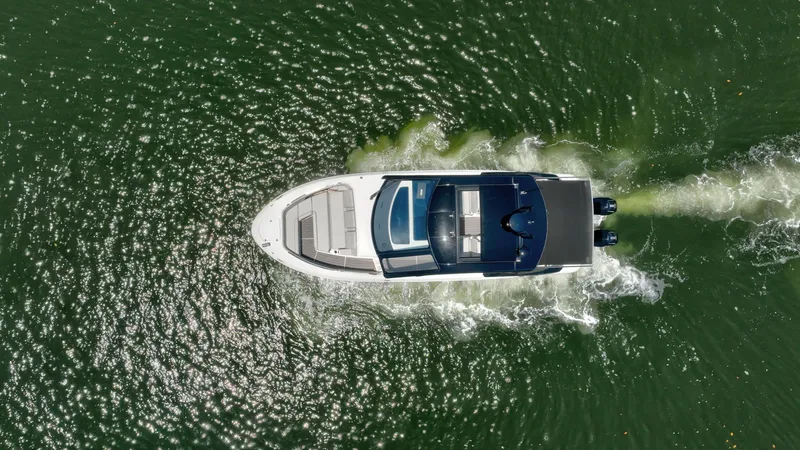  Yacht Photos Pics Aerial view of 2024 Sea Ray Sundancer 370 Outboard cruising on green water.