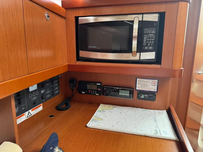 Bel Canto Yacht Photos Pics Interior of 2014 Beneteau 37 yacht with microwave, navigation equipment, and map.