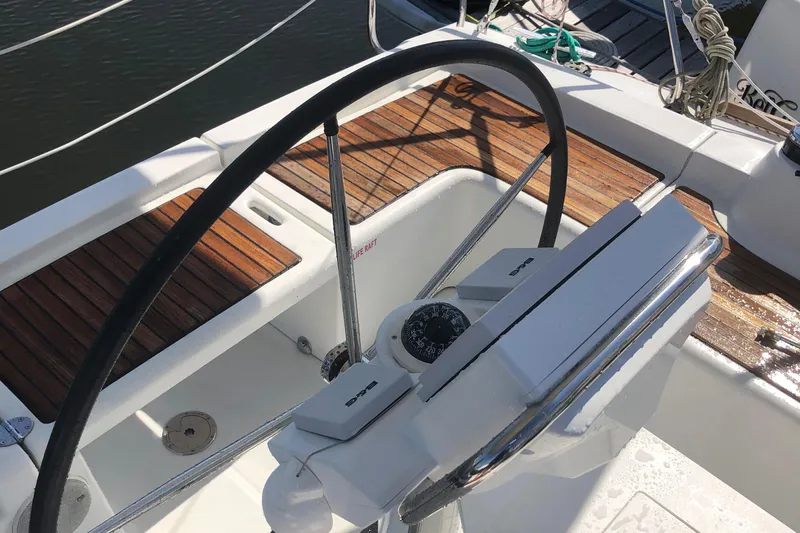 Bel Canto Yacht Photos Pics Steering wheel and compass on a 2014 Beneteau 37 sailboat deck.