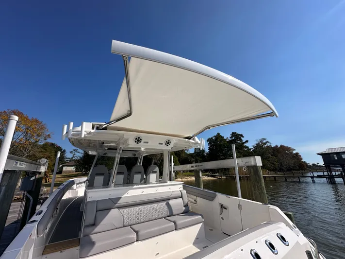  Yacht Photos Pics 2026 Regal 38 SAV boat with canopy, docked by a serene waterfront.