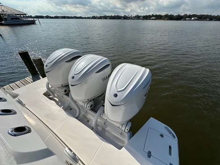  Yacht Photos Pics 2026 Regal 38 SAV boat with triple Yamaha outboard engines on a calm lake.
