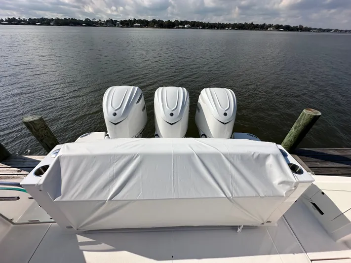  Yacht Photos Pics 2026 Regal 38 SAV boat with triple outboard engines docked by the water.