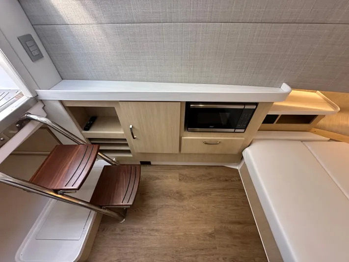  Yacht Photos Pics Modern interior of 2026 Regal 38 SAV yacht with microwave and wooden steps.