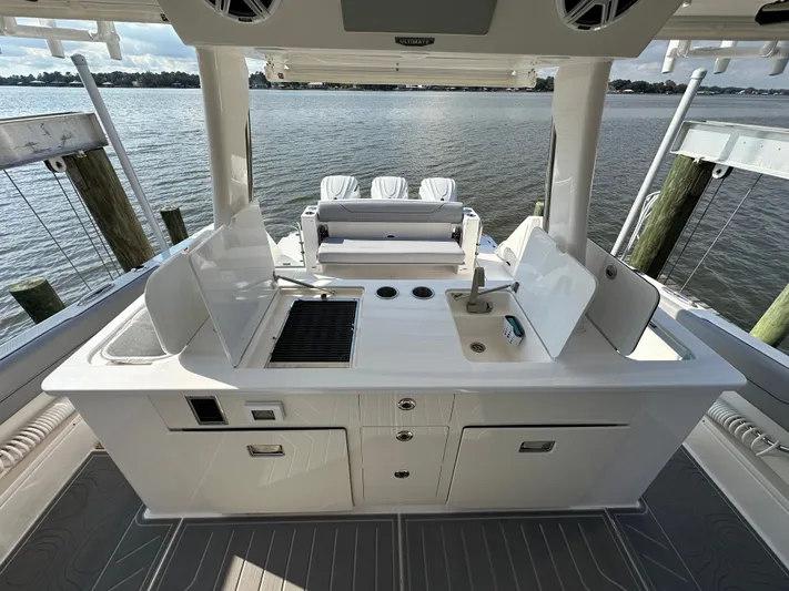  Yacht Photos Pics 2026 Regal 38 SAV boat kitchen area with sink, grill, and storage, overlooking water.