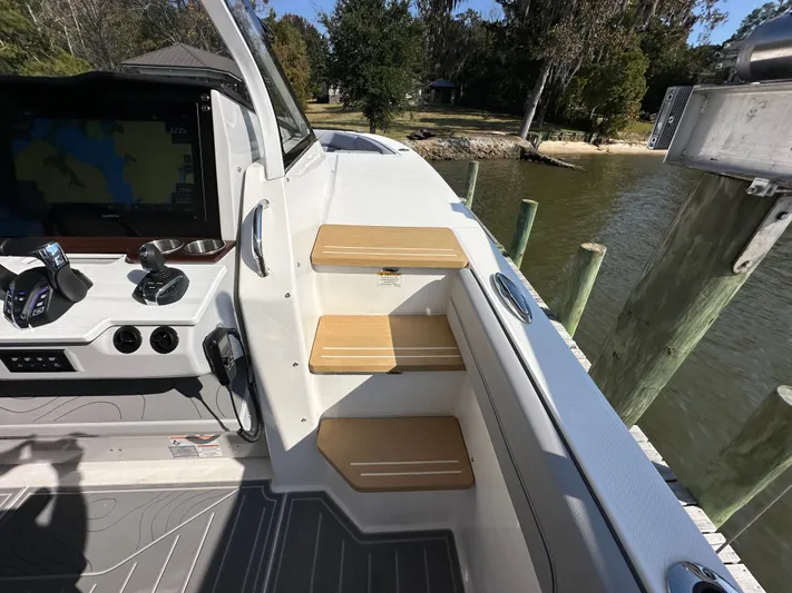  Yacht Photos Pics 2026 Regal 38 SAV boat interior with helm controls and wooden steps by a dock.