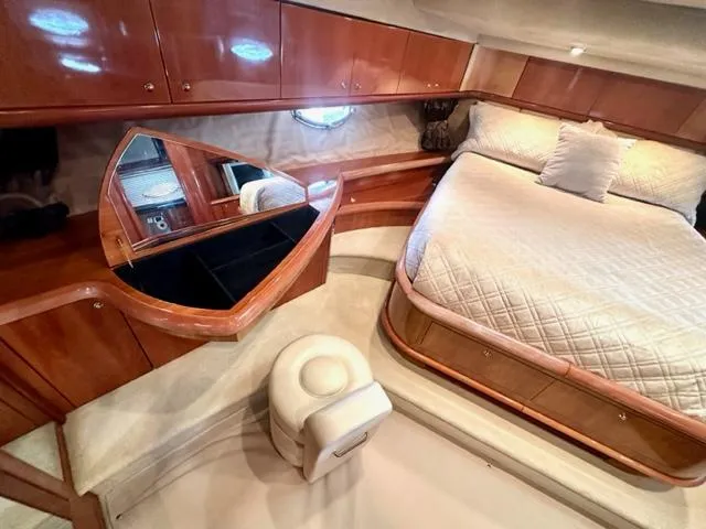 Interim Yacht Photos Pics Luxurious bedroom interior of 2002 Sunseeker 75 Predator yacht with bed and vanity.