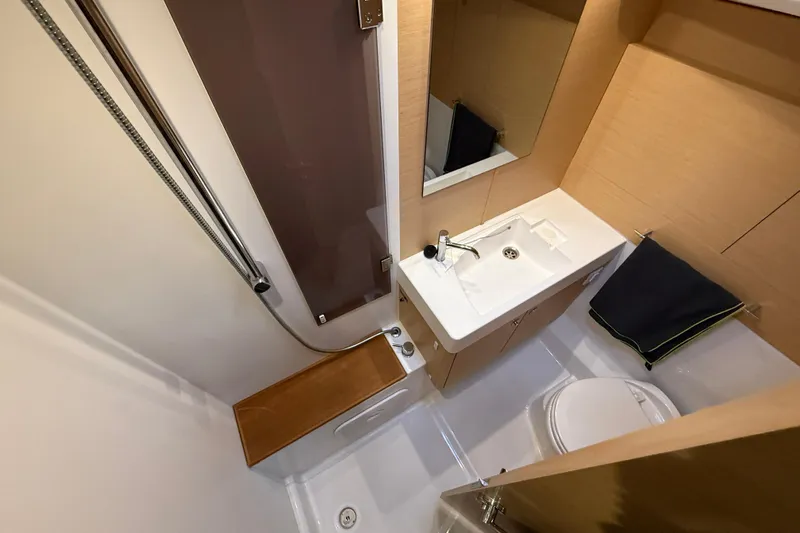 Shaboom Yacht Photos Pics Bathroom interior of 2017 Jeanneau Sun Odyssey 479 yacht, featuring sink, toilet, and shower.