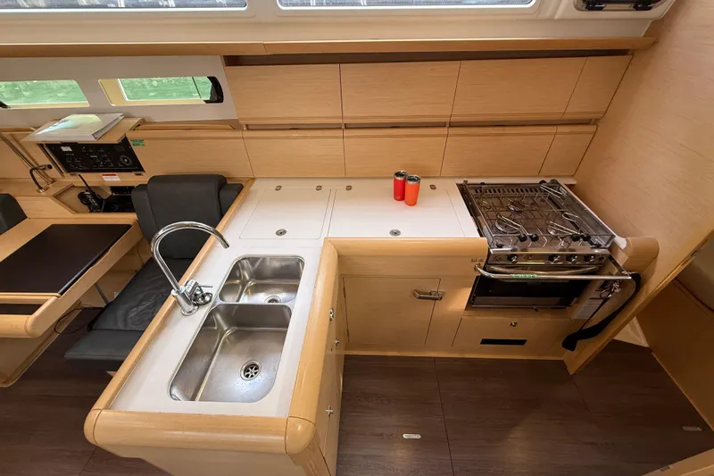 Shaboom Yacht Photos Pics Modern kitchen in 2017 Jeanneau Sun Odyssey 479 yacht with stove, sink, and storage.