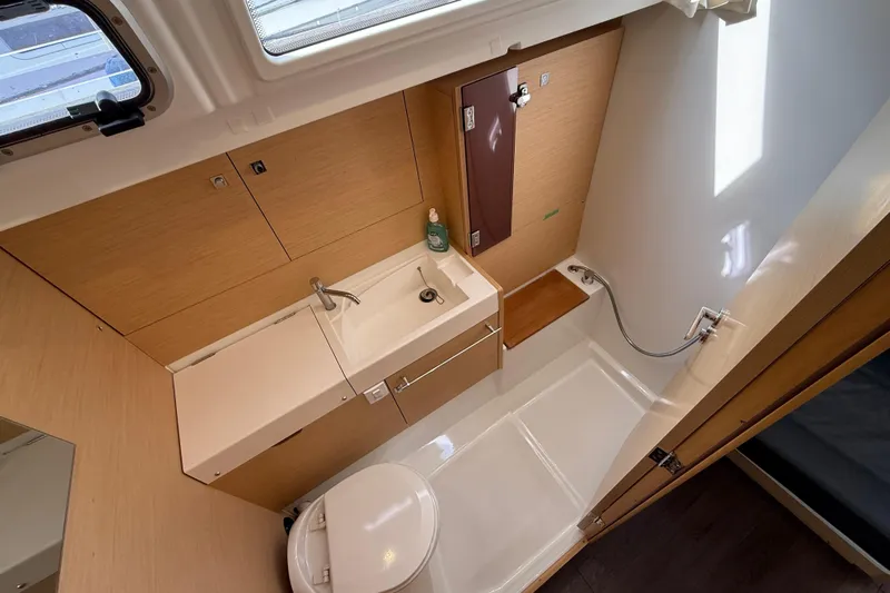 Shaboom Yacht Photos Pics 2017 Jeanneau Sun Odyssey 479 bathroom with modern fixtures and wooden accents.