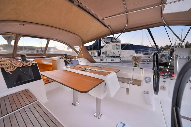 Mayne Deck Yacht Photos Pics 2019 Dufour 382 Grand Large yacht cockpit with wooden table and seating area.
