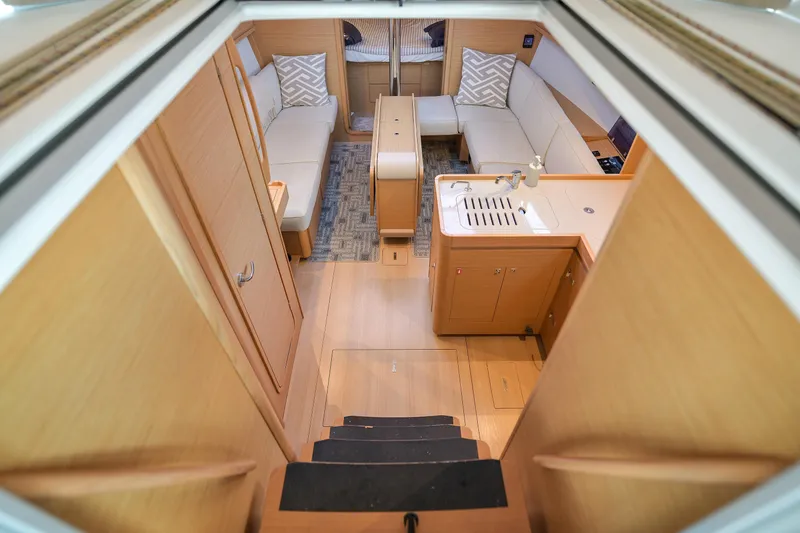 Mayne Deck Yacht Photos Pics Interior of 2019 Dufour 382 Grand Large yacht, featuring cozy seating and compact kitchen area.