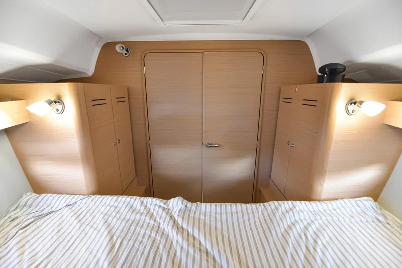 Mayne Deck Yacht Photos Pics 2019 Dufour 382 Grand Large cabin interior with wood finish and striped bedding.