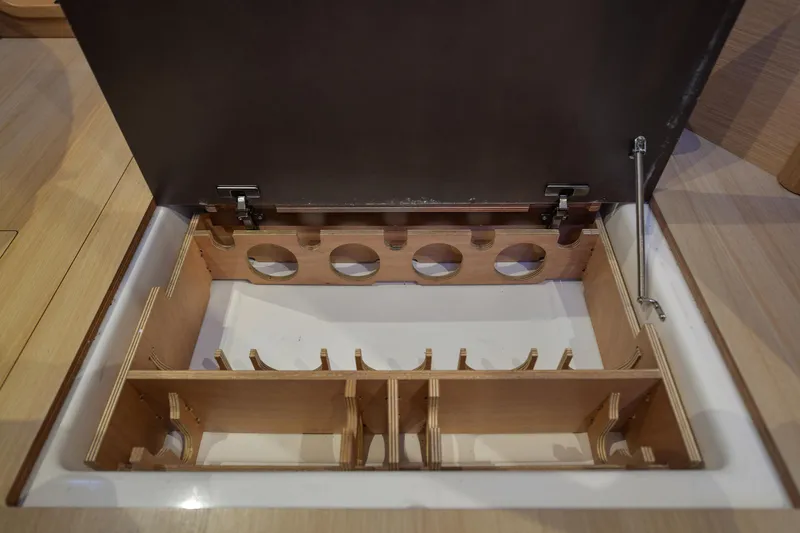 Mayne Deck Yacht Photos Pics Storage compartment in 2019 Dufour 382 Grand Large yacht, featuring wooden dividers and hinges.
