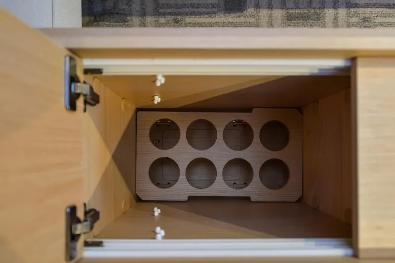 Mayne Deck Yacht Photos Pics Wooden storage compartment with circular cutouts in a 2019 Dufour 382 Grand Large yacht.