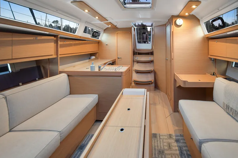 Mayne Deck Yacht Photos Pics Interior of 2019 Dufour 382 Grand Large yacht, featuring modern wood finish and cozy seating.
