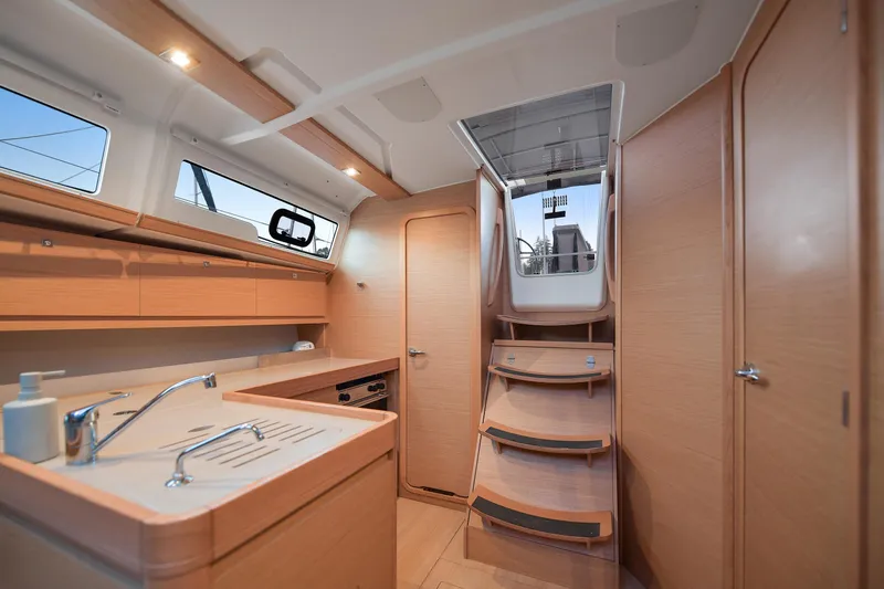 Mayne Deck Yacht Photos Pics Interior of 2019 Dufour 382 Grand Large yacht, featuring modern kitchen and wooden cabinetry.