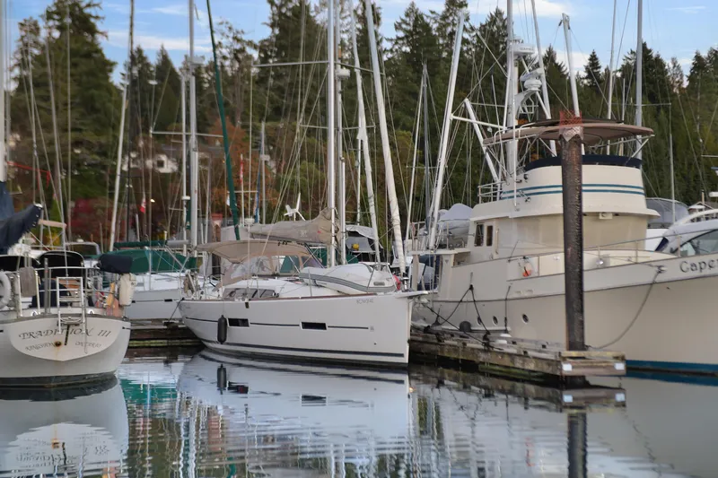 Mayne Deck Yacht Photos Pics 2019 Dufour 382 Grand Large sailboat docked in a serene marina setting.