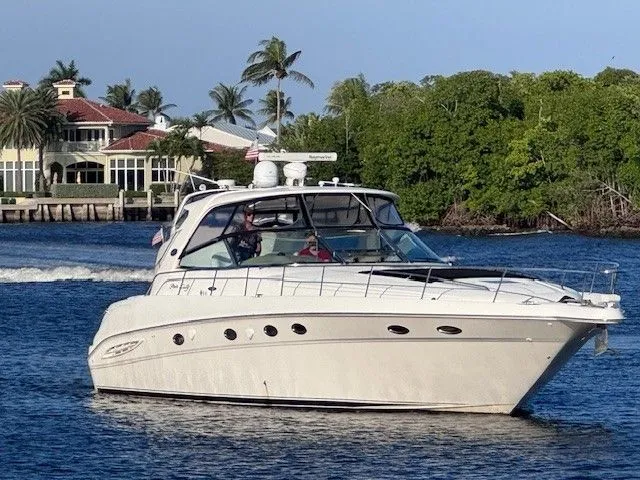  Yacht Photos Pics 2002 Sea Ray 460 Sundancer yacht cruising on calm waters near shore.