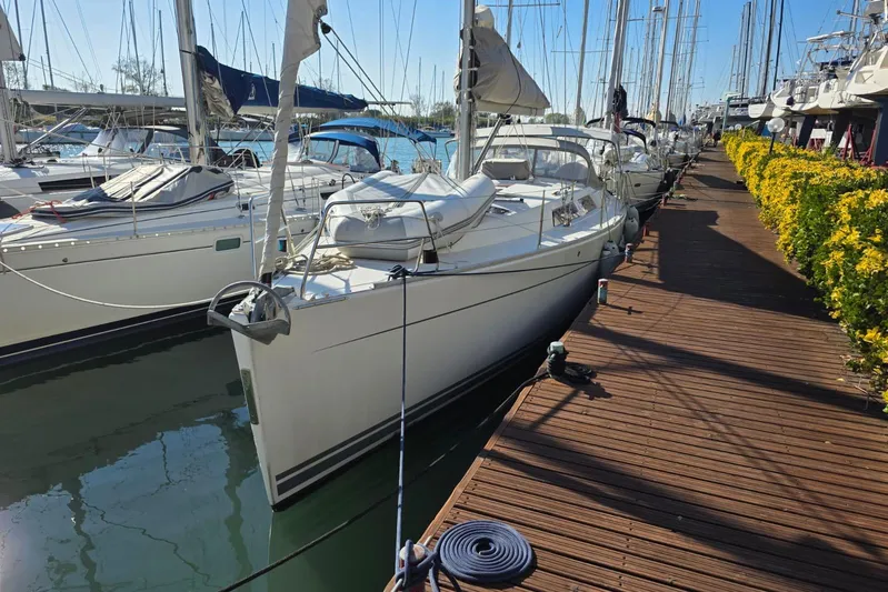  Yacht Photos Pics 2010 Hanse 400e sailboat docked at a marina with wooden walkway and yellow flowers.