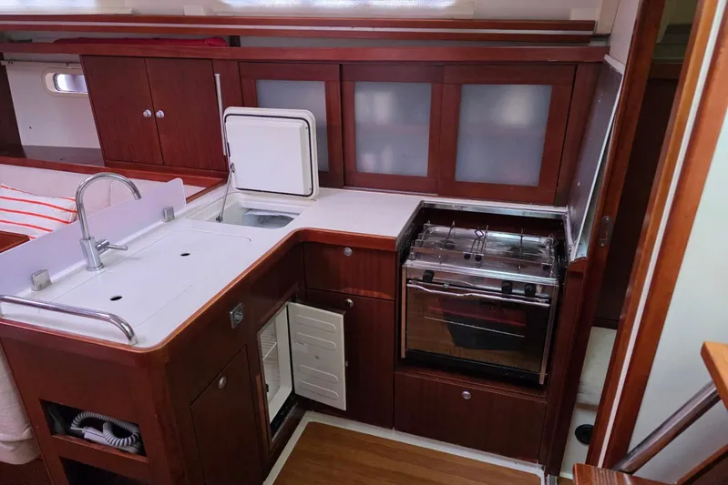  Yacht Photos Pics 2010 Hanse 400e yacht interior kitchen with wooden cabinets, sink, and stove.