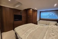 Luxurious cabin interior of 2014 Princess V48 Open yacht with cozy bed and seating area.
