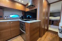 Luxurious 2014 Princess V48 Open yacht kitchen with modern wood cabinetry and appliances.