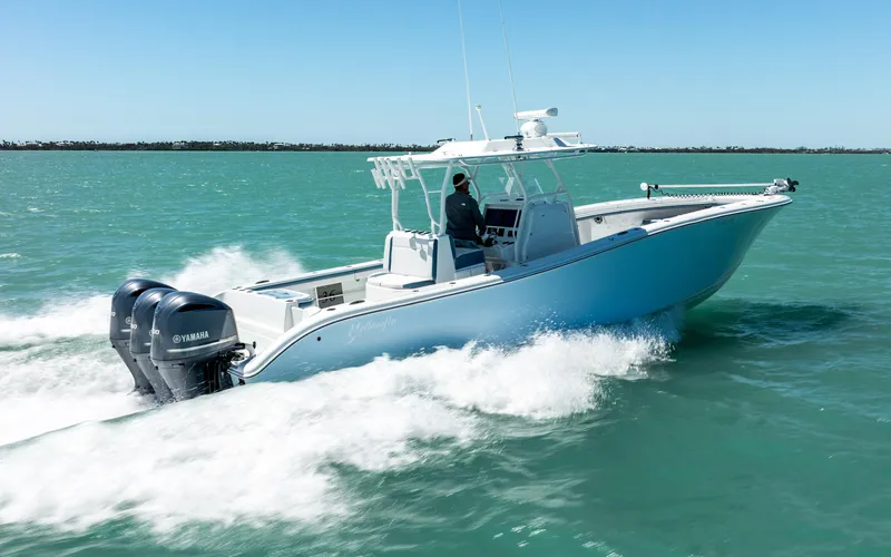  Yacht Photos Pics 2019 Yellowfin 36 boat cruising on turquoise water with triple Yamaha engines.