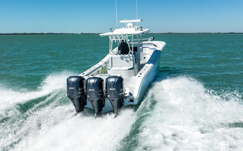  Yacht Photos Pics 2019 Yellowfin 36 boat cruising on open water with triple outboard engines.