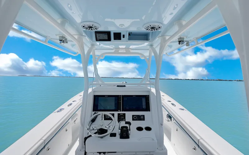  Yacht Photos Pics 2019 Yellowfin 36 boat interior with steering console, on calm blue water under a clear sky.