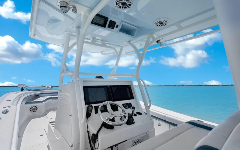  Yacht Photos Pics 2019 Yellowfin 36 boat interior with steering wheel, ocean view, and clear blue sky.