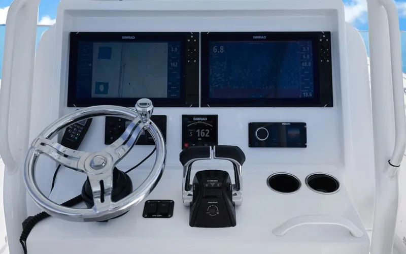  Yacht Photos Pics Control panel of a 2019 Yellowfin 36 boat with steering wheel and navigation screens.