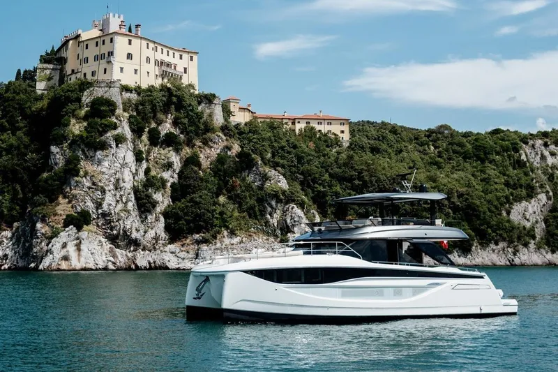 M7 Yacht Photos Pics Luxurious 2026 Prestige yacht cruising near a scenic cliffside villa.